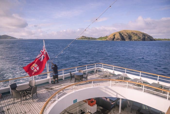 Captain Cook Cruises Yasaway Islands seen from reef Endeavour as Fijian flag is raised