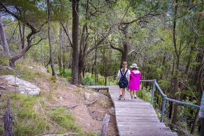 image shows two girls walking down wooden steps on Flint and Steel Bay walk