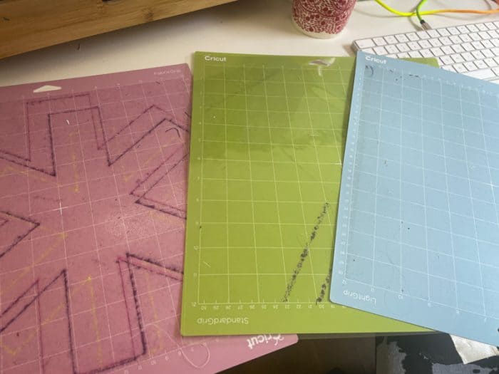 three different mats for the Cricut craft machine pink green and blue