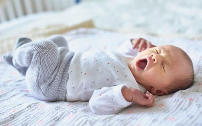 image of newborn baby yawning to illustrate article about having a baby at 40